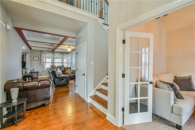 interior space with beam ceiling, ceiling fan, coffered ceiling, and hardwood / wood-style flooring