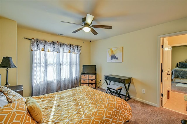 carpeted bedroom featuring connected bathroom and ceiling fan