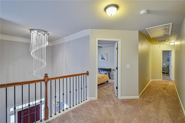 corridor featuring carpet, a chandelier, and crown molding