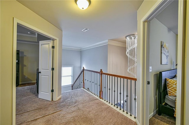 corridor with carpet, a notable chandelier, and ornamental molding