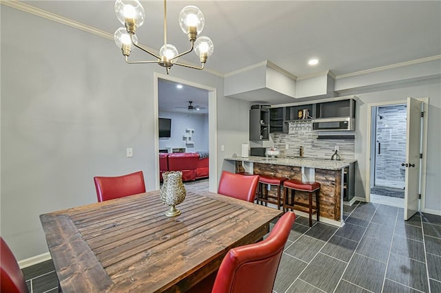 dining area featuring ceiling fan with notable chandelier and ornamental molding