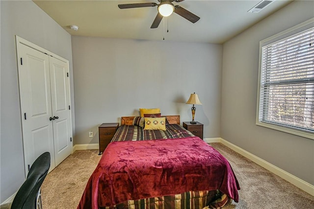 bedroom with multiple windows, ceiling fan, and light colored carpet