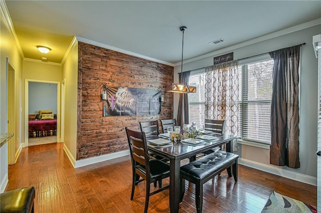 dining space featuring wood-type flooring and ornamental molding