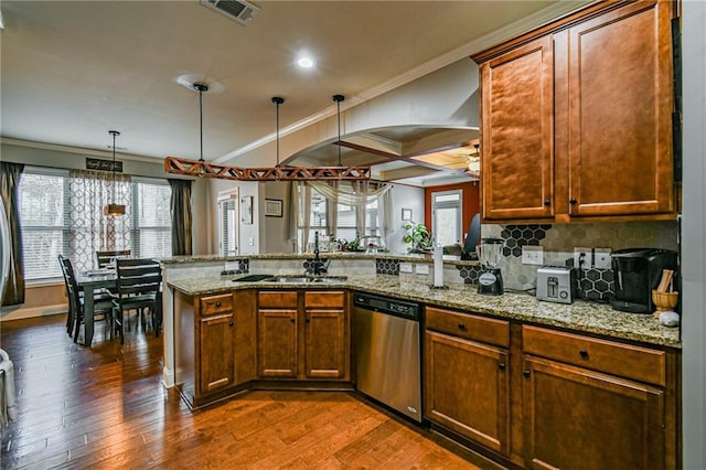 kitchen featuring kitchen peninsula, stainless steel dishwasher, ornamental molding, dark wood-type flooring, and hanging light fixtures