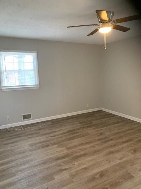 spare room featuring dark hardwood / wood-style floors and ceiling fan