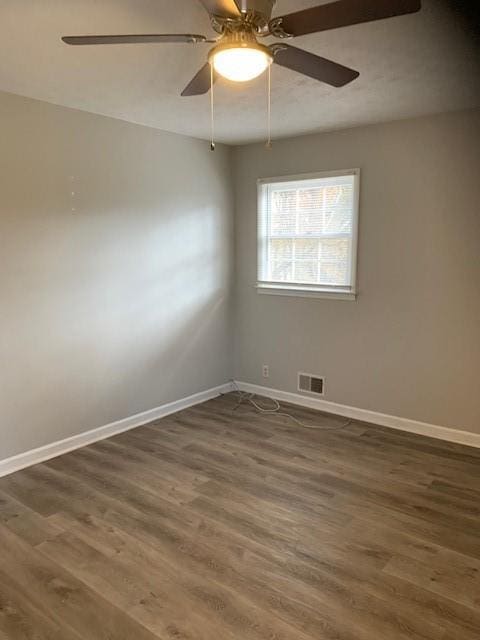 spare room with dark hardwood / wood-style floors and ceiling fan