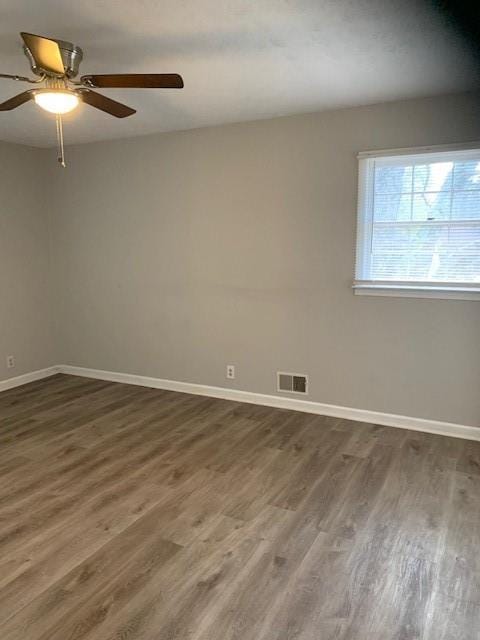 empty room featuring ceiling fan and dark hardwood / wood-style flooring