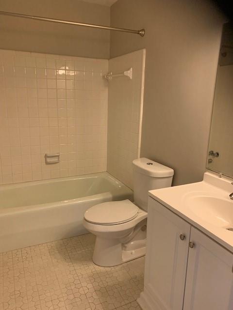 full bathroom with toilet, vanity, and tiled shower / bath