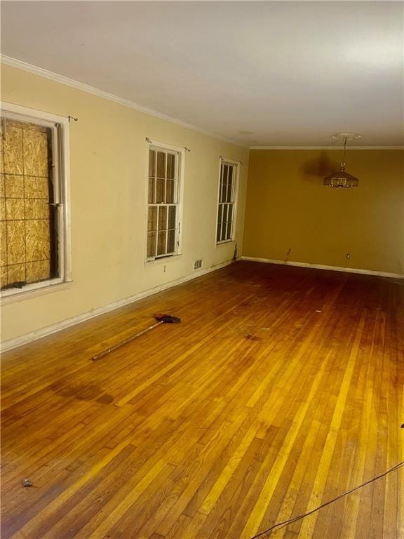 empty room featuring hardwood / wood-style flooring and ornamental molding