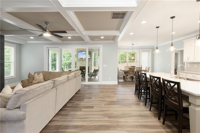 living room with light wood-style floors, a ceiling fan, plenty of natural light, baseboards, and recessed lighting