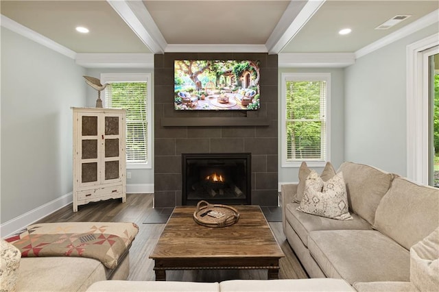 living area with wood finished floors, baseboards, ornamental molding, a fireplace, and recessed lighting