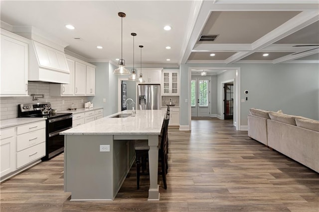 kitchen with stainless steel appliances, a sink, open floor plan, a breakfast bar area, and decorative backsplash