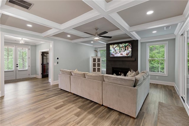 living room with a large fireplace, baseboards, light wood finished floors, coffered ceiling, and ceiling fan