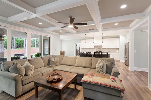 living room featuring coffered ceiling, light wood finished floors, beamed ceiling, a ceiling fan, and recessed lighting
