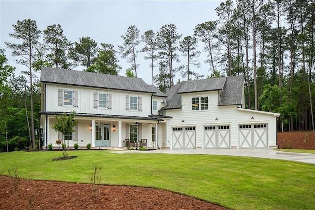 modern inspired farmhouse with board and batten siding, driveway, covered porch, and a front yard