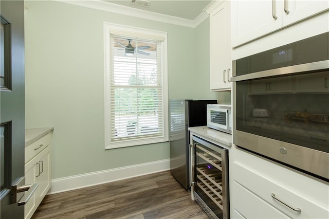 kitchen featuring wine cooler, crown molding, baseboards, dark wood-style flooring, and white cabinetry