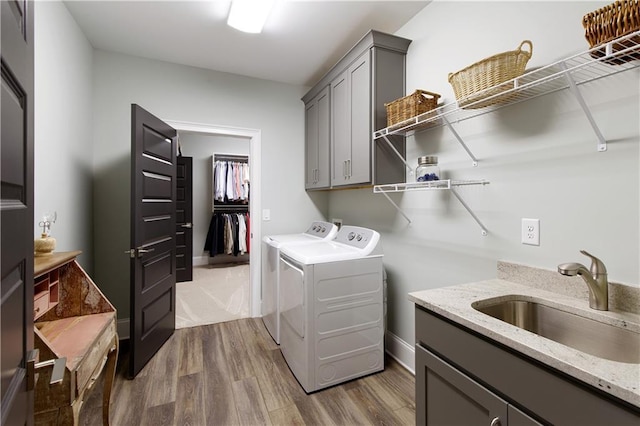 clothes washing area with washer and clothes dryer, cabinet space, and dark wood-style floors