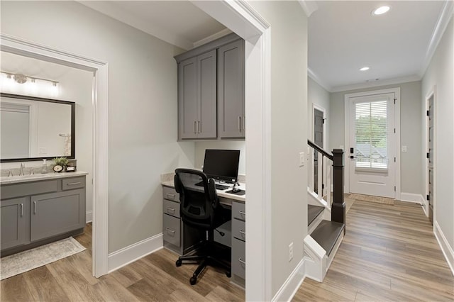 home office with a sink, ornamental molding, light wood-style flooring, baseboards, and recessed lighting