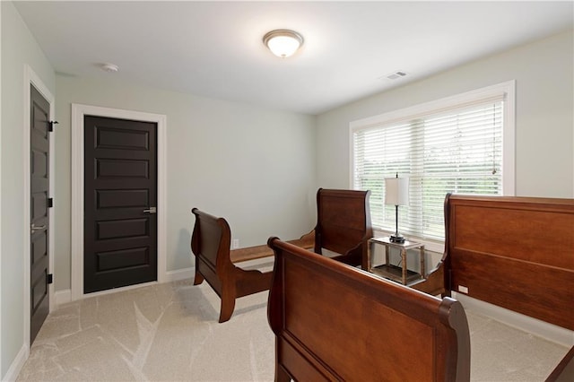 bedroom featuring light carpet and baseboards
