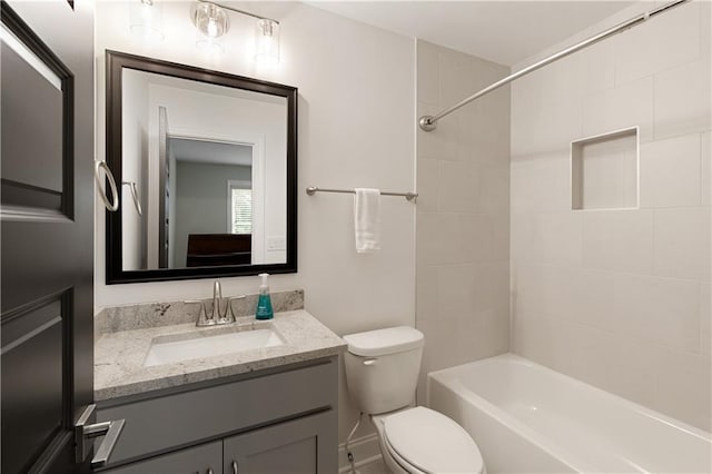 bathroom with toilet, vanity, and  shower combination