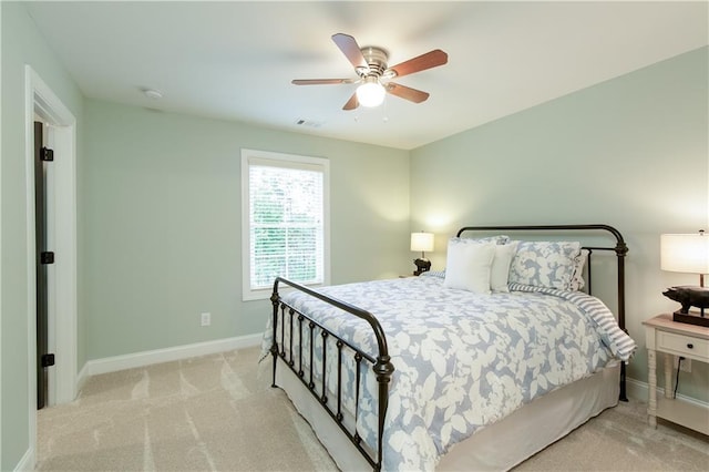 bedroom featuring baseboards, light carpet, and a ceiling fan