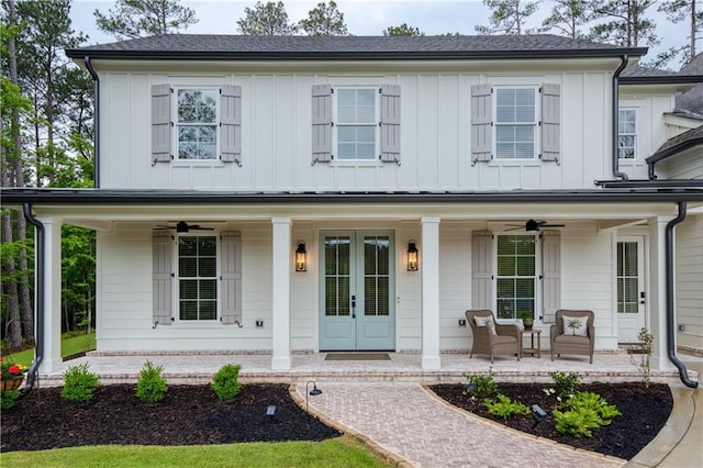 modern inspired farmhouse with covered porch, a ceiling fan, board and batten siding, and french doors