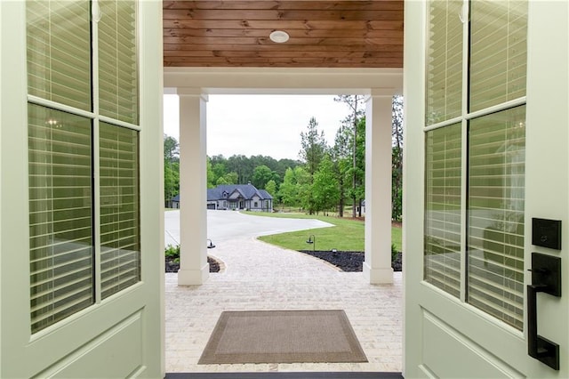 doorway to outside featuring wooden ceiling and carpet