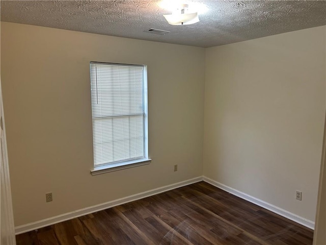 504 Edgewood Trce, Mcdonough, GA 30253 - empty room featuring dark wood-type flooring, plenty of natural light, and a textured ceiling