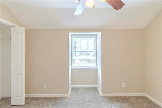 spare room with lofted ceiling, carpet flooring, and baseboards