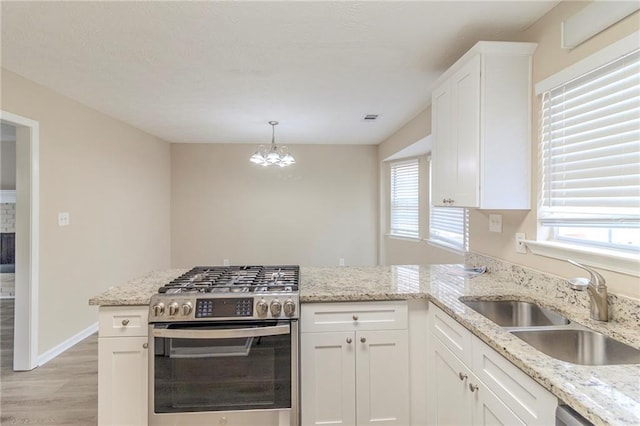 kitchen featuring a healthy amount of sunlight, appliances with stainless steel finishes, a peninsula, and a sink