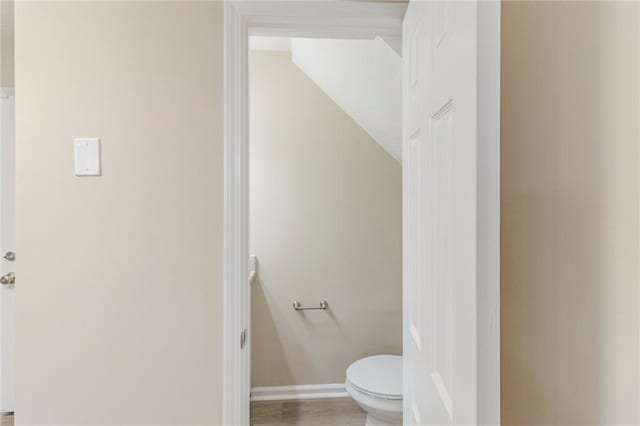 bathroom with baseboards and toilet