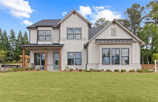 rear view of property featuring a lawn and covered porch