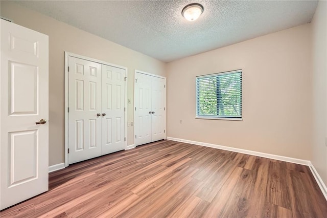 1800 Clairmont Lk Unit A310, Decatur, GA 30033 - unfurnished bedroom featuring two closets, light wood-style floors, and a textured ceiling