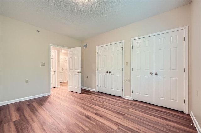 1800 Clairmont Lk Unit A310, Decatur, GA 30033 - unfurnished bedroom with two closets, wood finished floors, and a textured ceiling
