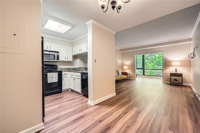 1800 Clairmont Lk Unit A310, Decatur, GA 30033 - kitchen featuring black appliances, crown molding, open floor plan, light wood-type flooring, and white cabinetry