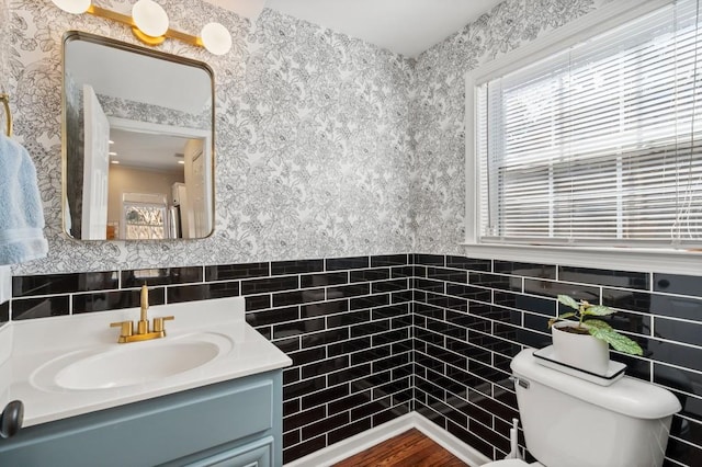 bathroom with vanity, tile walls, and toilet