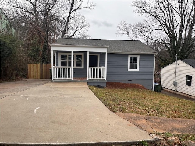 view of front of property featuring a porch, fence, roof with shingles, crawl space, and a front lawn