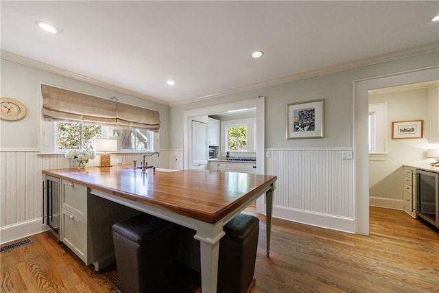 202 Lakeview Ave, Atlanta, GA 30305 - kitchen with ornamental molding, a wainscoted wall, dark wood-type flooring, visible vents, and a sink