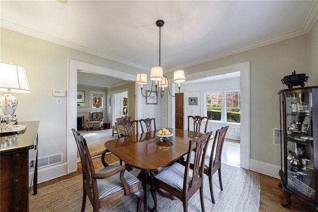 202 Lakeview Ave, Atlanta, GA 30305 - dining space featuring visible vents, baseboards, an inviting chandelier, ornamental molding, and wood finished floors