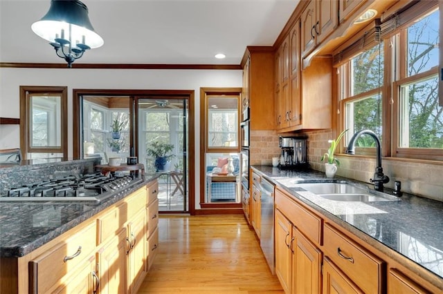 kitchen with stainless steel appliances, ornamental molding, sink, and pendant lighting