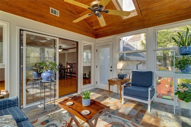 sunroom / solarium featuring ceiling fan, a wealth of natural light, lofted ceiling with skylight, and wooden ceiling