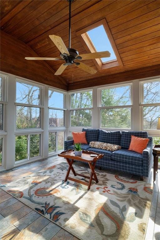 sunroom / solarium with ceiling fan, lofted ceiling with skylight, and wooden ceiling