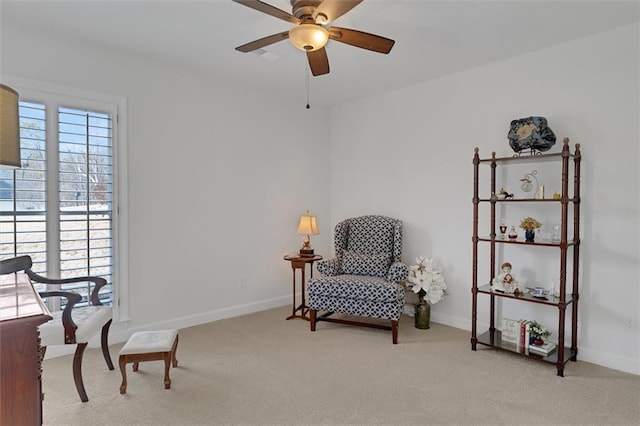 living area featuring light carpet and ceiling fan