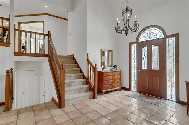 tiled entrance foyer featuring a notable chandelier and high vaulted ceiling