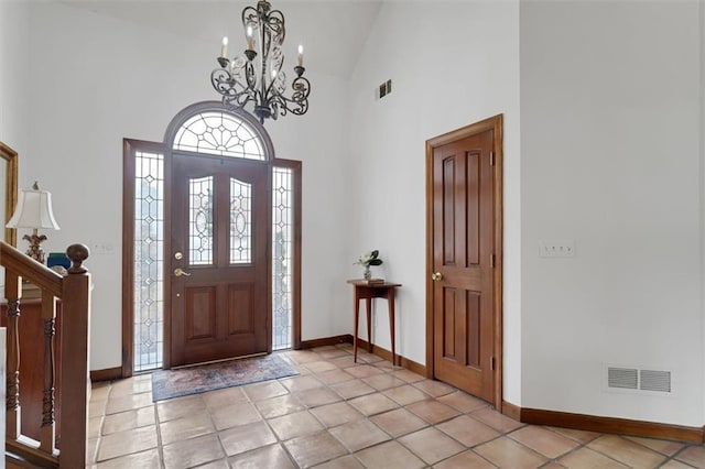 tiled entrance foyer with a notable chandelier and high vaulted ceiling