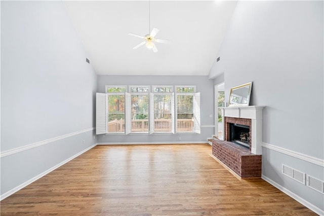 unfurnished living room featuring ceiling fan, a fireplace, high vaulted ceiling, and light wood-type flooring