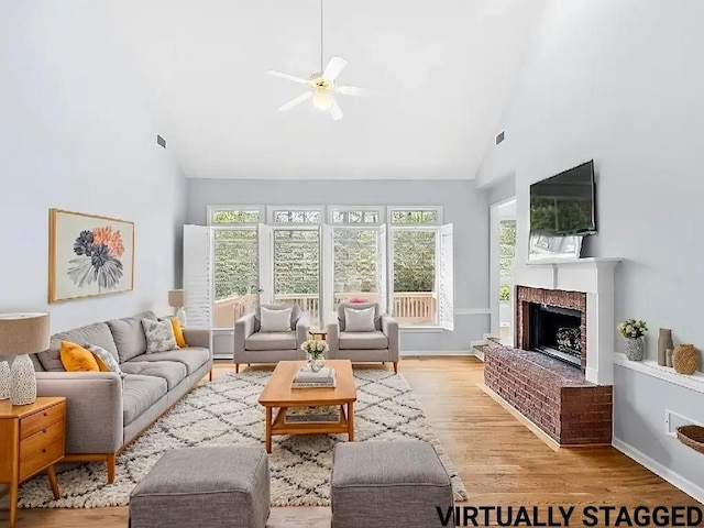 living room featuring ceiling fan, light wood-type flooring, and high vaulted ceiling