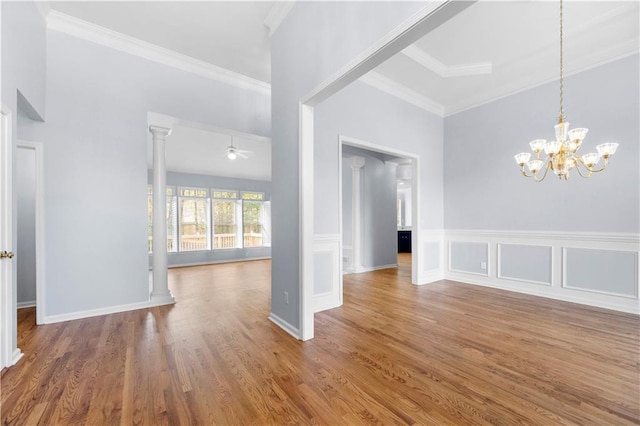 interior space featuring crown molding, ceiling fan with notable chandelier, ornate columns, and hardwood / wood-style flooring