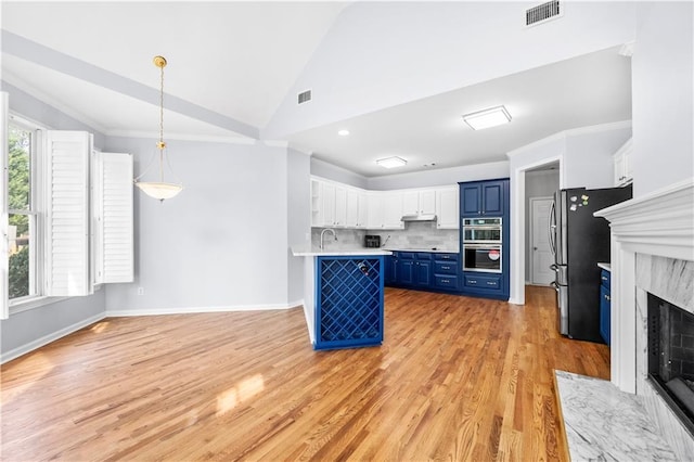 kitchen featuring a breakfast bar, white cabinetry, hanging light fixtures, stainless steel appliances, and blue cabinets