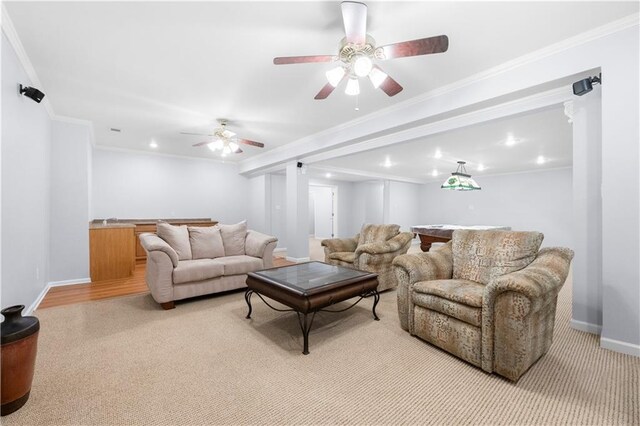 carpeted living room featuring crown molding, sink, and ceiling fan